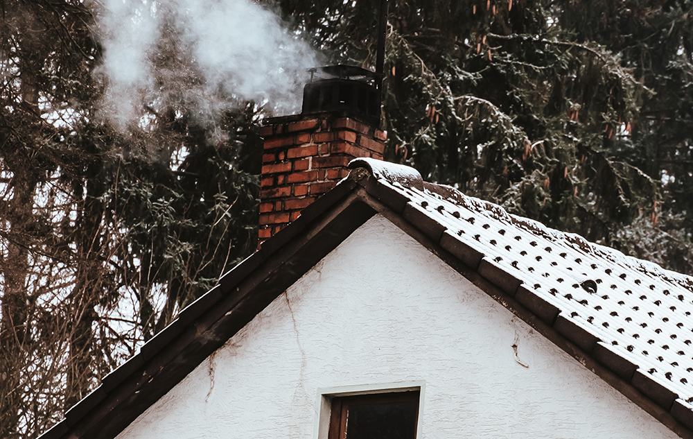 Smoking chimney with snow on roof